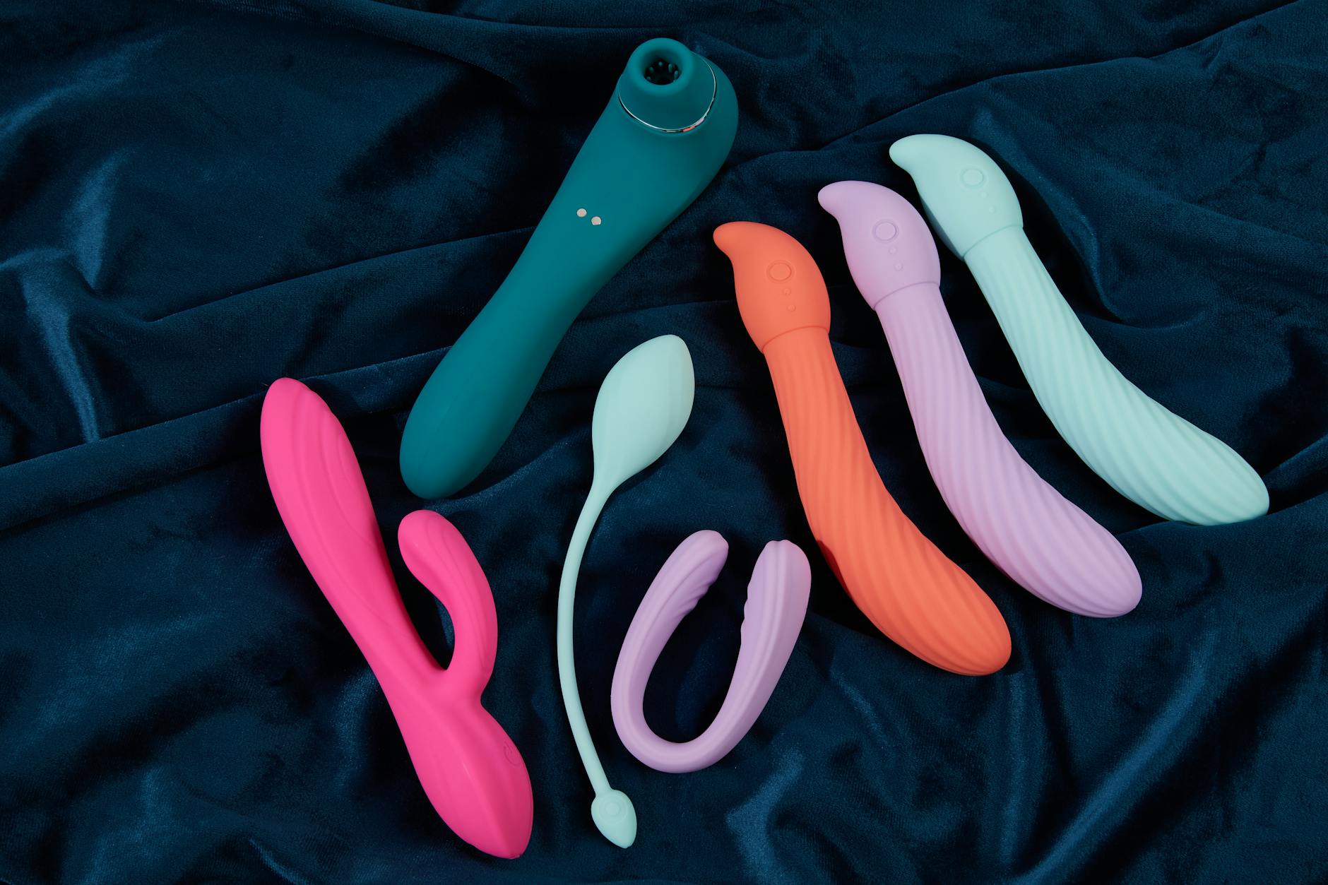 Pareja joven de pie juntos en interiores, sosteniendo juntos un vibrador azul, simbolizando la intimidad moderna y compartida