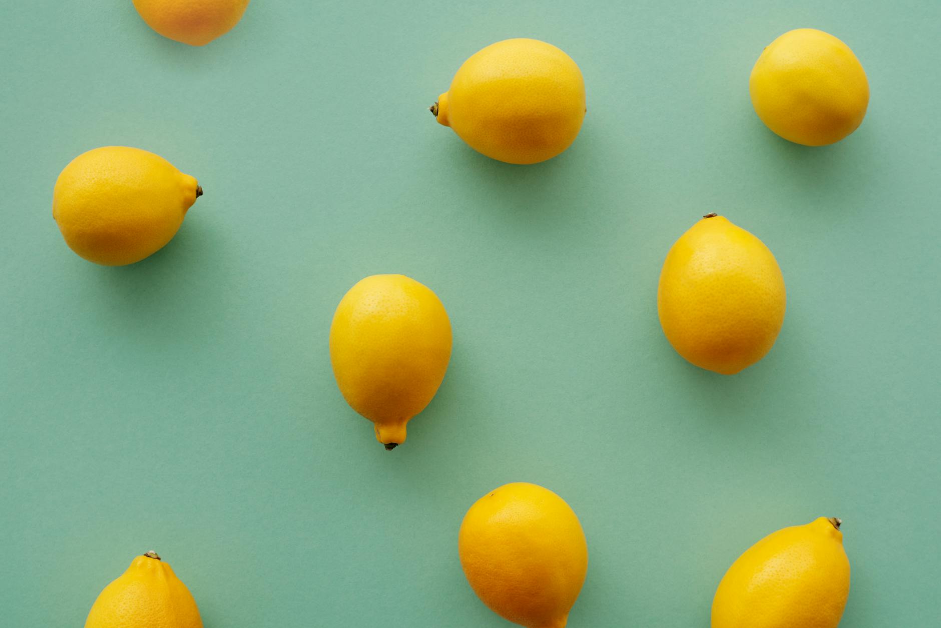 Bright yellow lemons arranged on a pastel background, symbolizing discreet pleasure and the quiet lemon vibrator