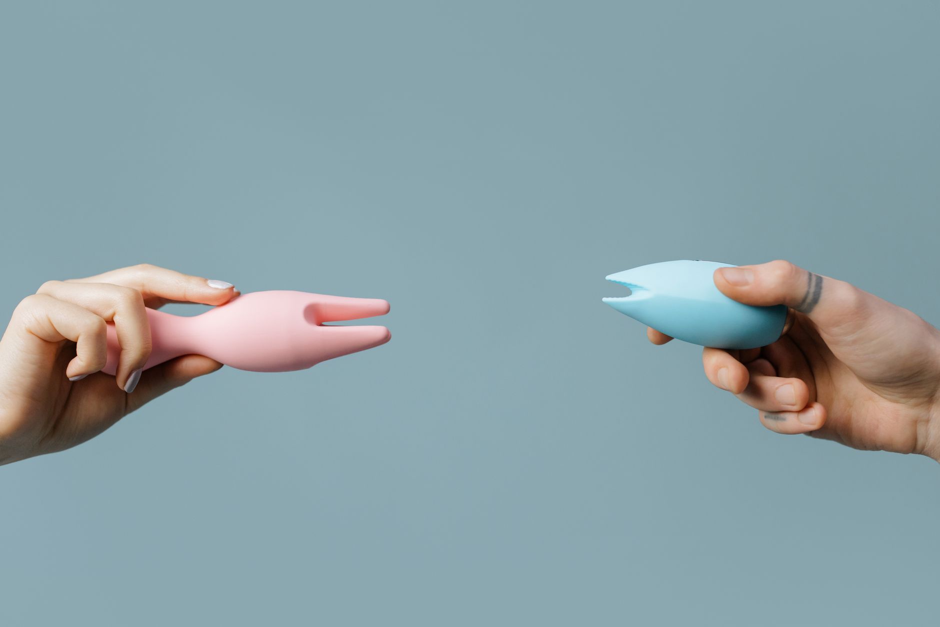 Two hands holding vibrators in different colors, symbolizing reconnection and exploring pleasure together.