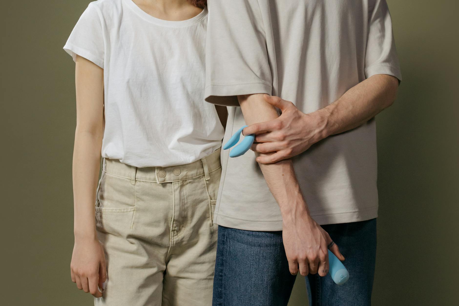 A couple holding a blue vibrator together, symbolizing modern intimacy and connection